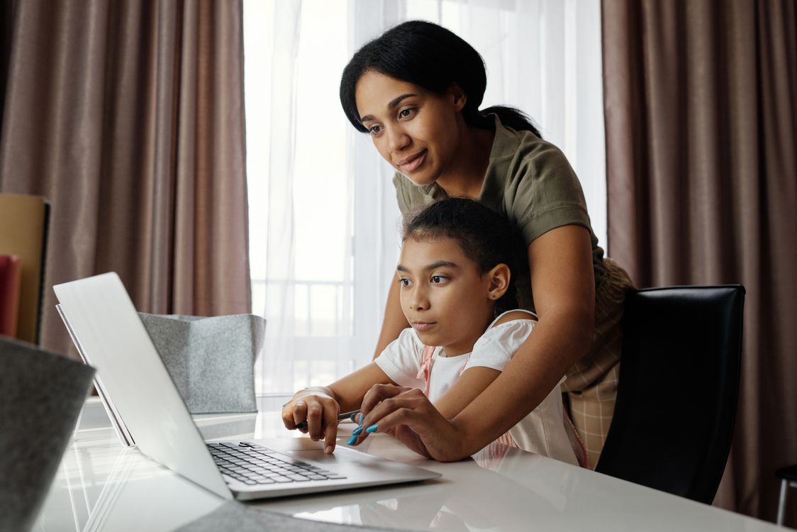Family using a laptop at home for online learning.